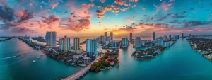 a breathtaking aerial view of miami's vibrant waterfront properties, showcasing sleek modern architecture surrounded by crystal-clear turquoise waters and lush tropical foliage under a radiant sunset sky.
